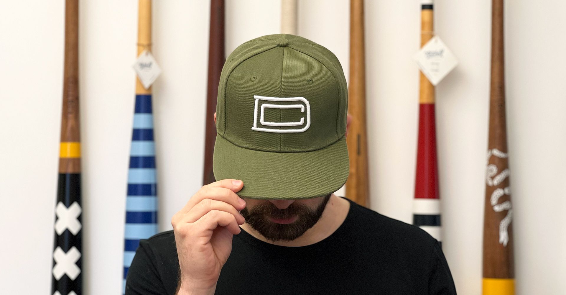 Dan wearing olive green hat with DC monogram